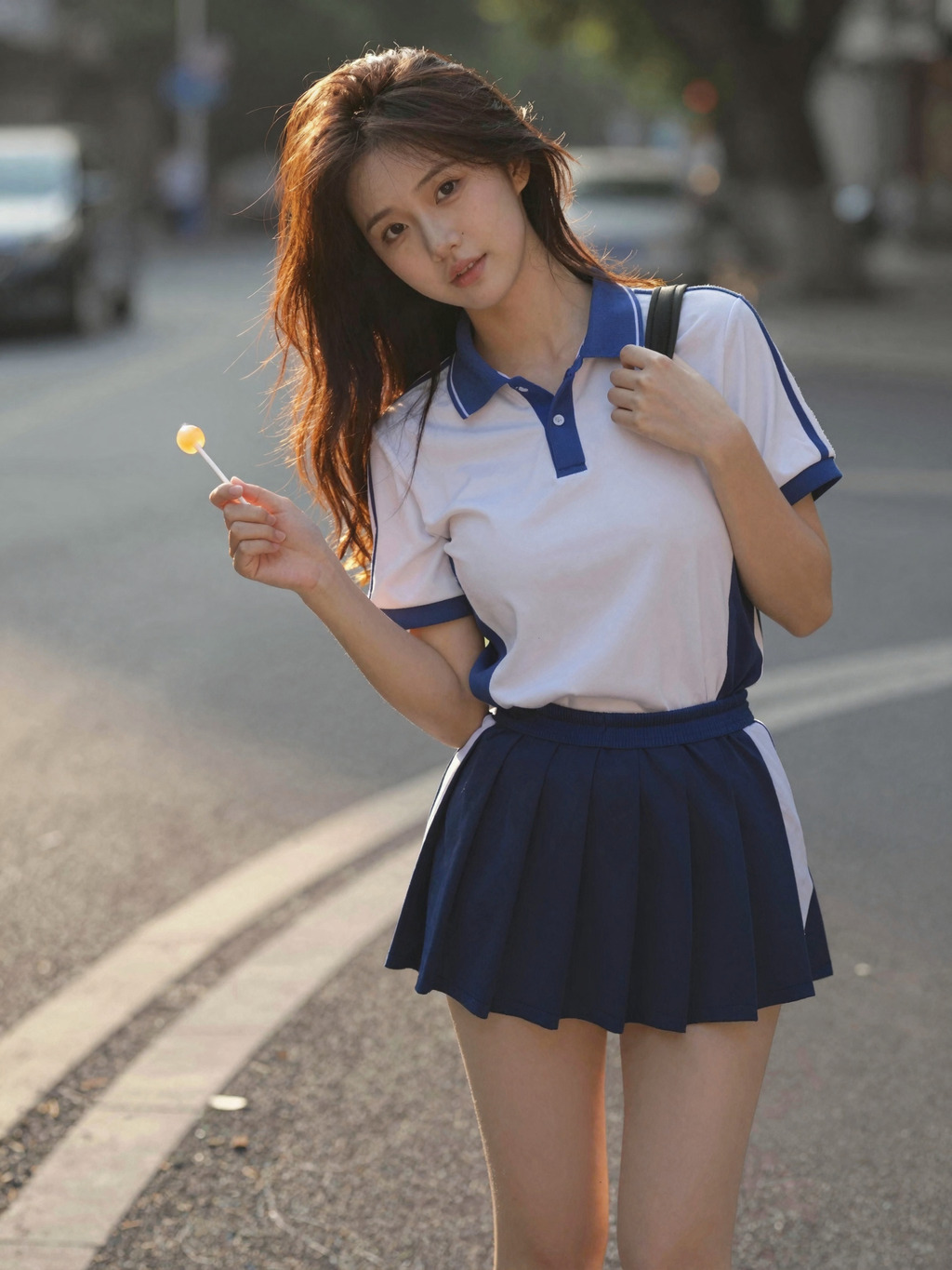 Sunlit street portrait in blue-and-white polo and pleated skirt